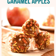 three candy coated mini caramel apples stacked on top of each other sitting on parchment paper.