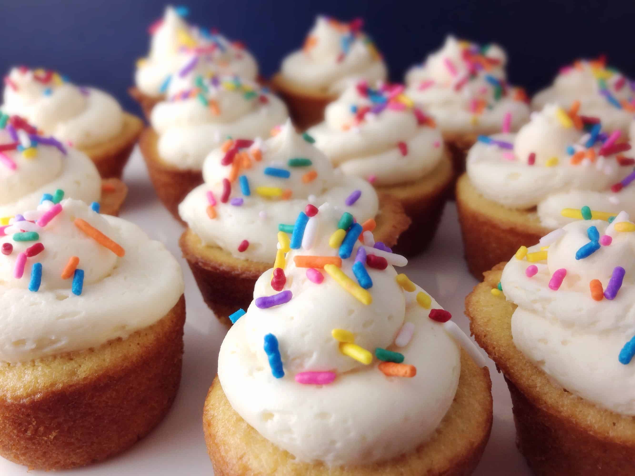 closeup of mini vanilla cupcakes with frosting on top