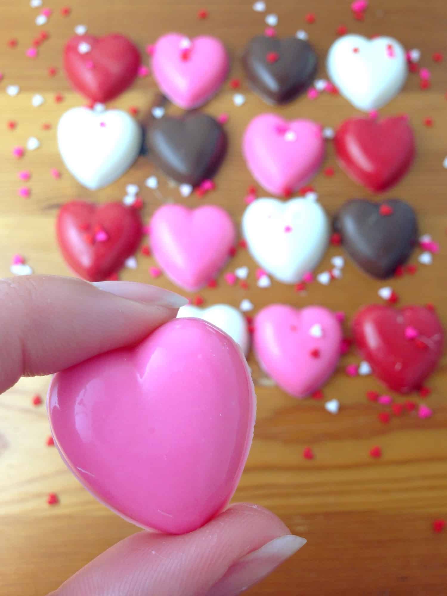 hand holding pink heart chocolate 