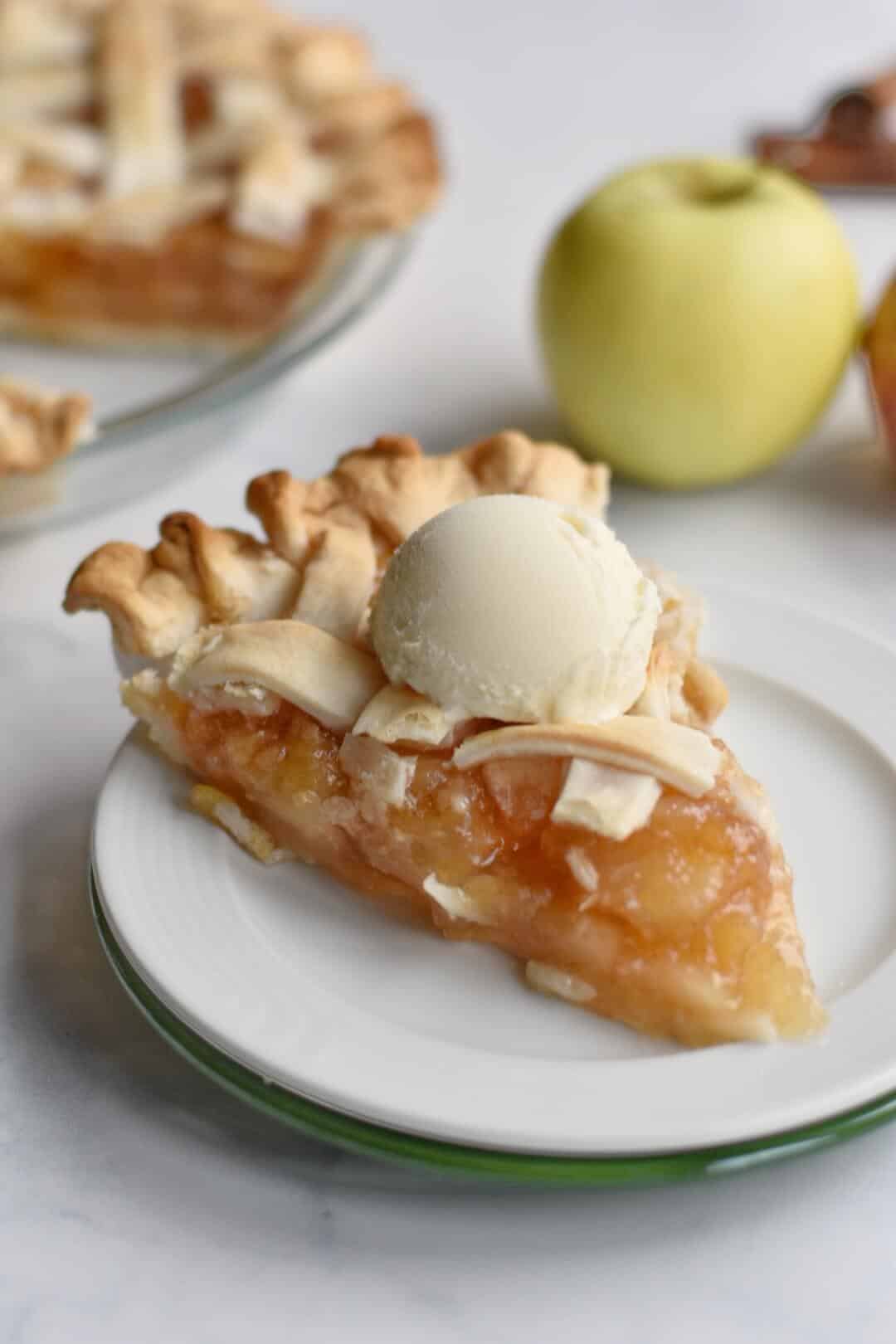 Homemade apple pie on a plate with ice cream.