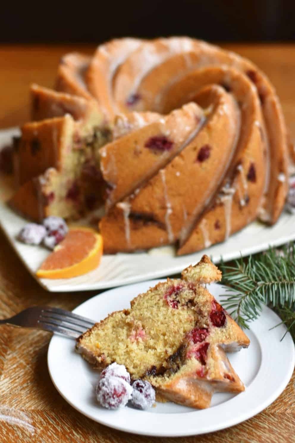 slice of cranberry orange bundt cake with cake in background