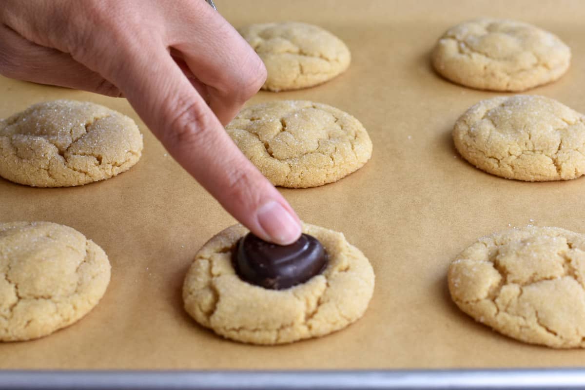finger pressing chocolate onto cooled cookie