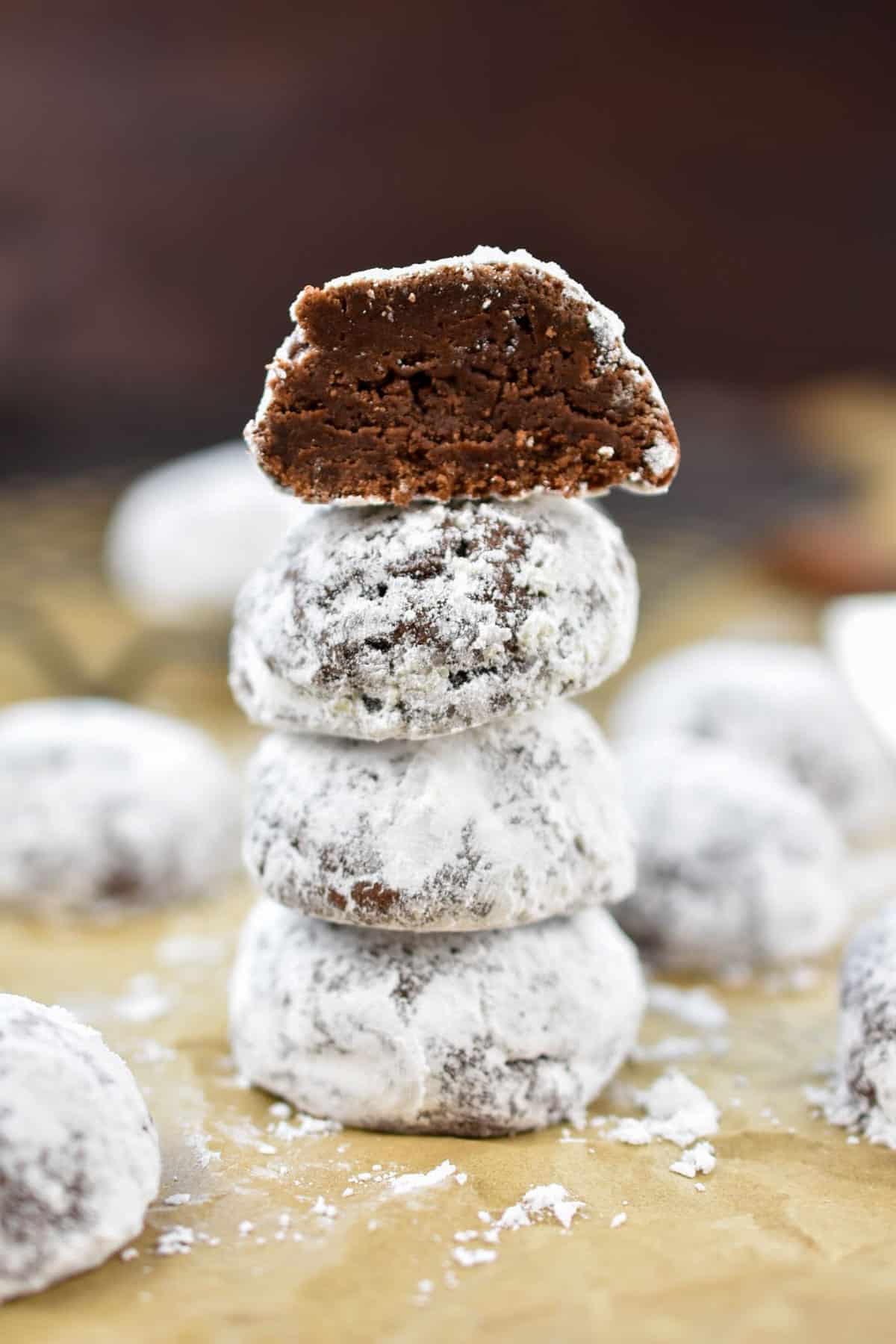 closeup of chocolate snowball cookies stacked on top of each other