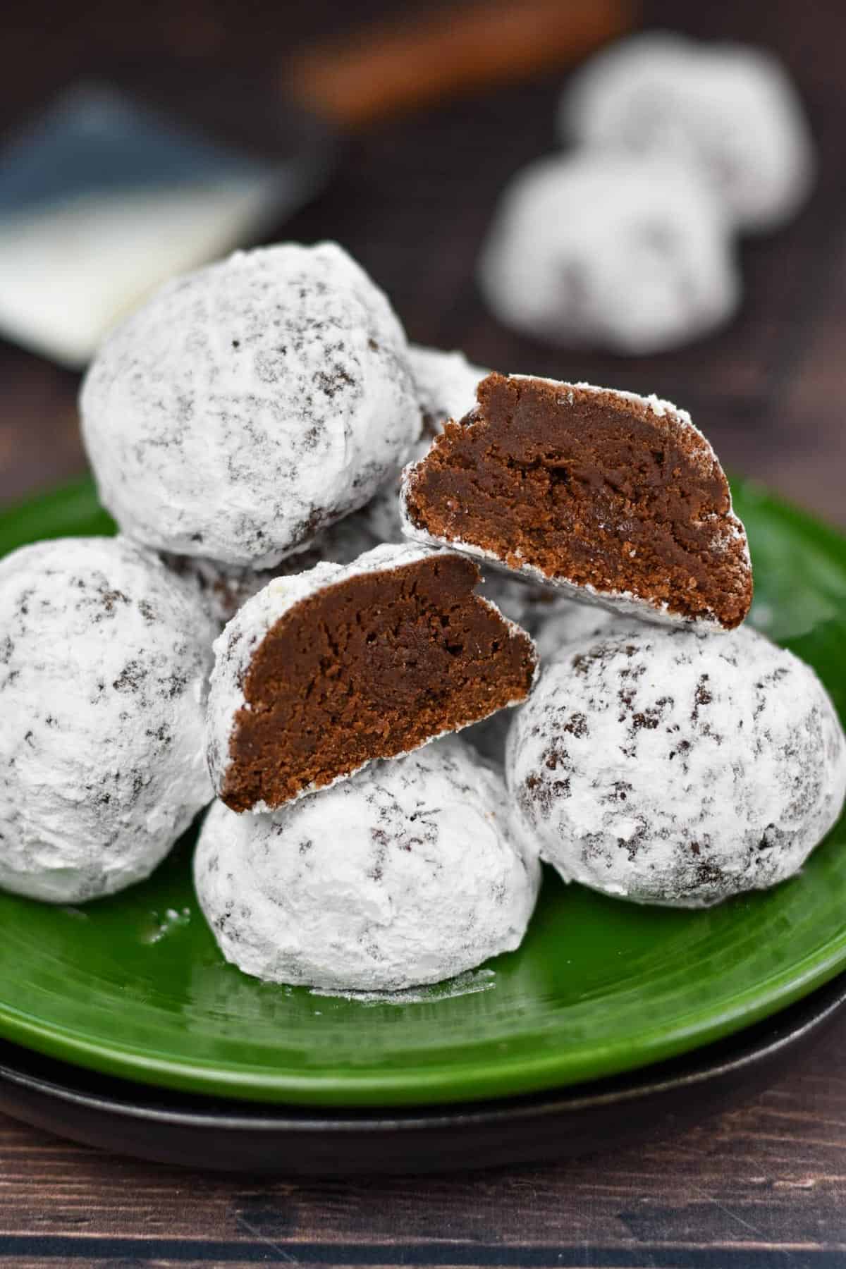 image of snowball cookies on a plate with one cookie cut open.