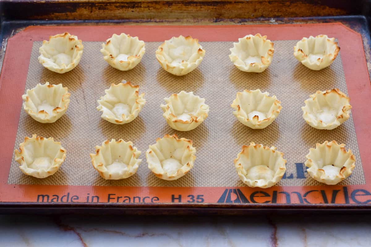 frozen phyllo shells lined up on baking sheet prior to filling.