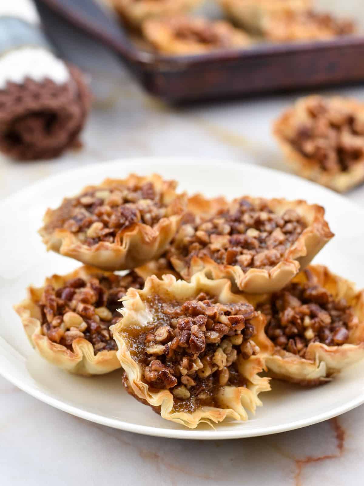 closeup image of mini pecan tarts sitting on a plate.
