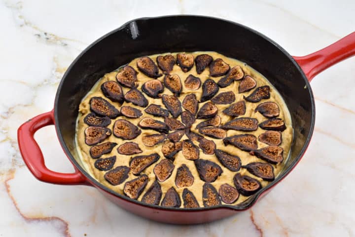 dried fig layered on top of batter in a p cast-iron skillet