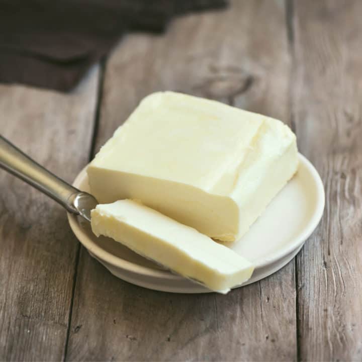 butter on a small white plate with a knife