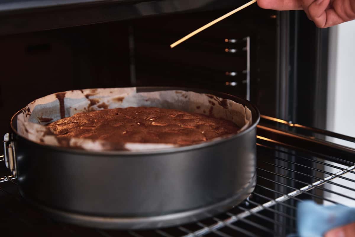 chocolate cake in oven with toothpick testing if done.