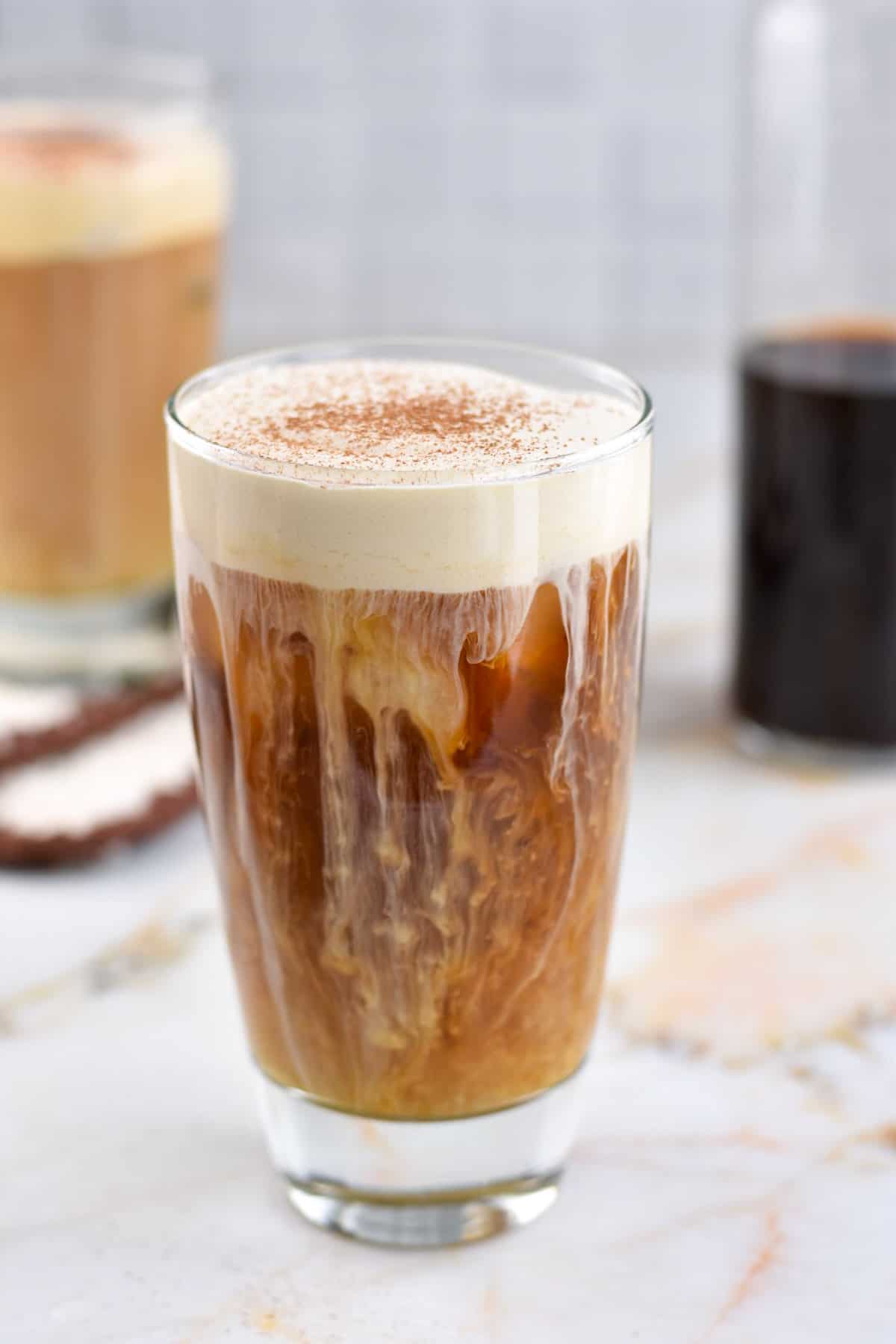 clear glass with cold brew coffee and irish cream on top cascading down