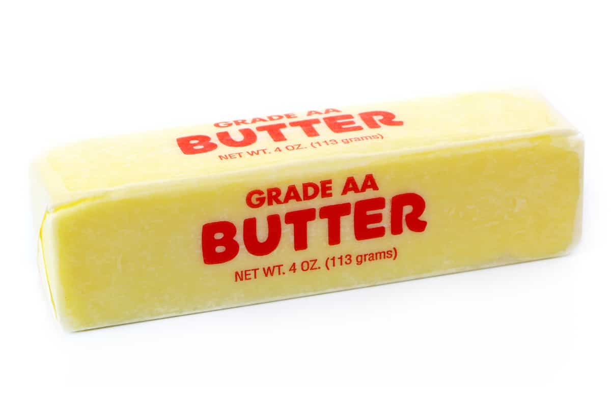 stick of butter in wrapper on the counter
