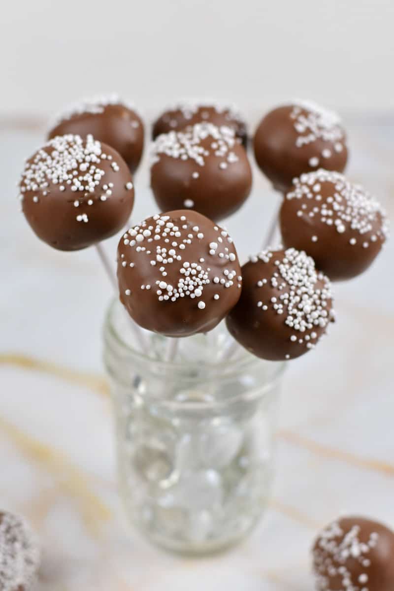 chocolate cake pops standing up in a clear glass