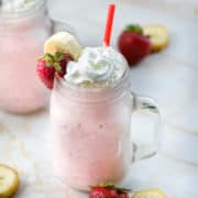 strawberry banana milkshake in a mason jar.