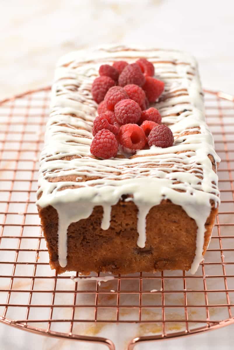 raspberry white chocolate loaf cake on cooling rack.