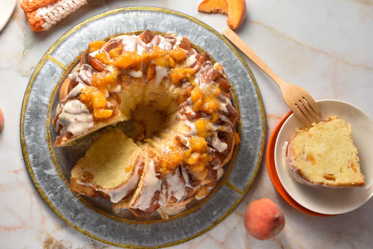 overhead shot of a peach cobbler pound cake on a plate.