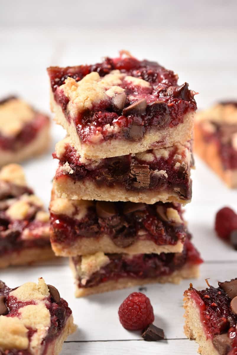 raspberry chocolate crumble bars four stacked high.
