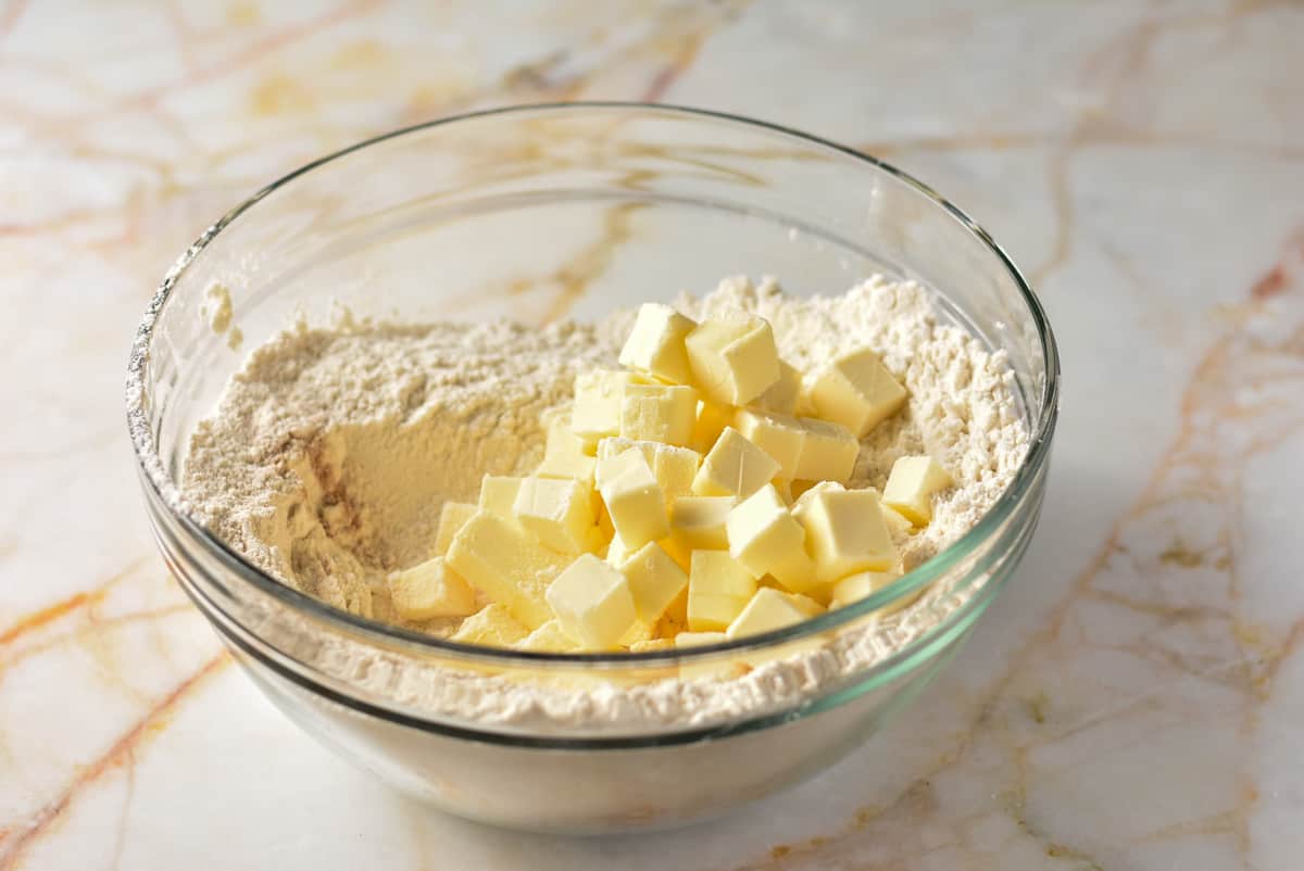 cubed cold butter and flour in a clear bowl.