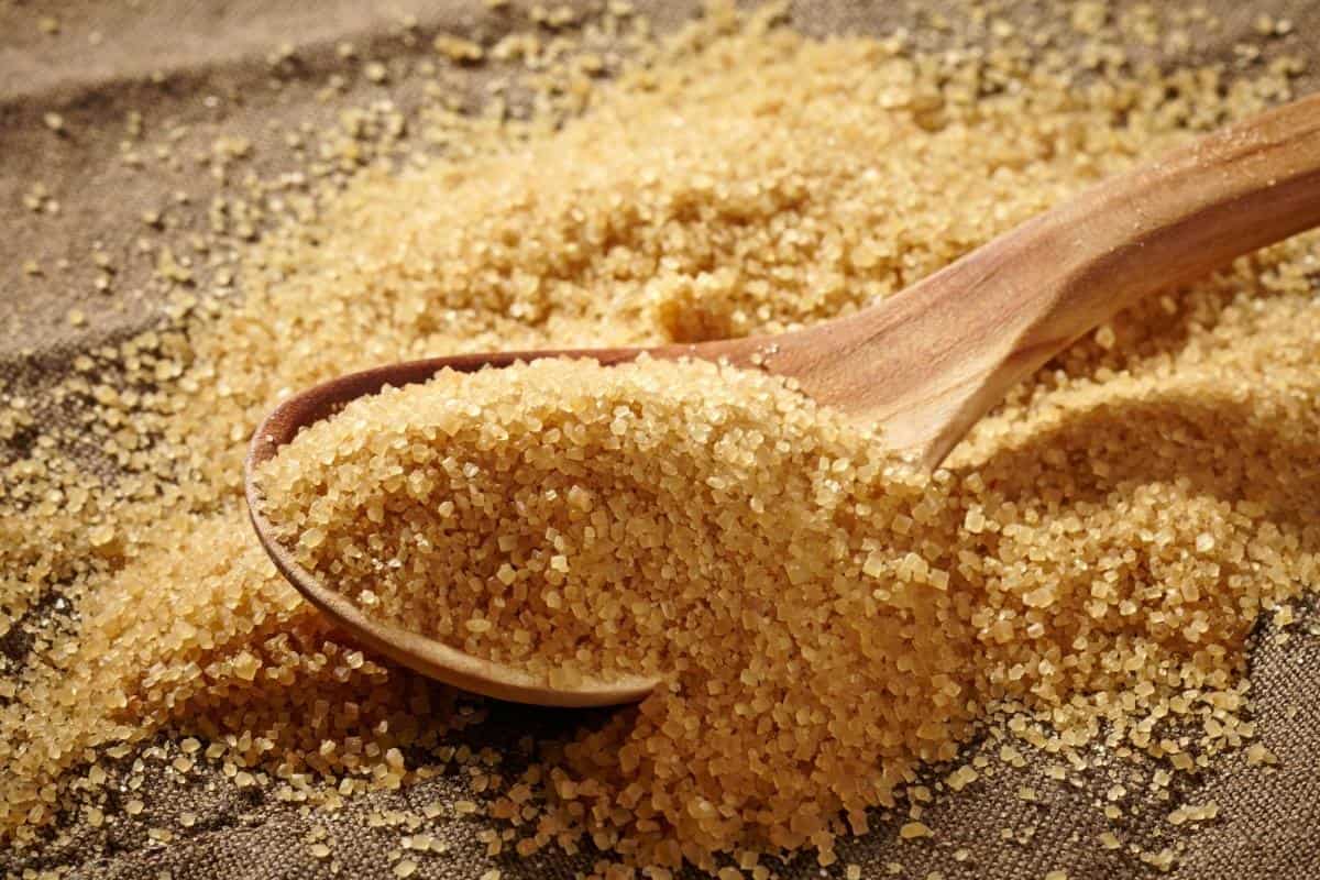 brown sugar in a bowl with a wooden spoon full of brown sugar.