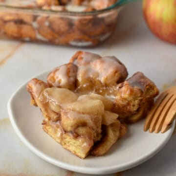 slice of cinnamon roll apple pie filling casserole on a plate.