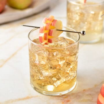 sprite and crown apple in a clear glass with apple garnish.