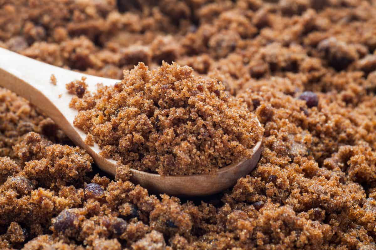 brown sugar in a bowl with a wooden spoon full of brown sugar.