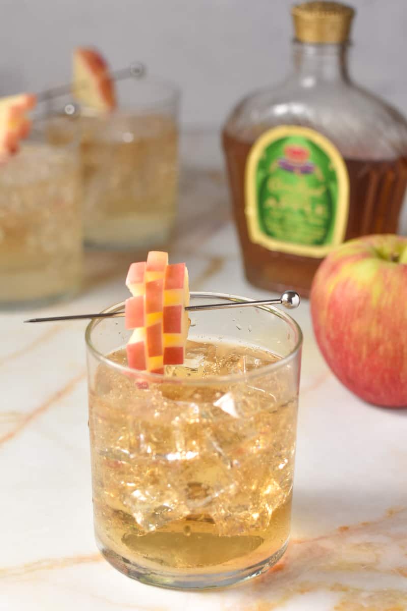 crown apple and sprite in glass with apple and crown bottle in background.