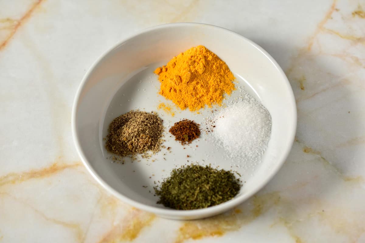 spices for sauce measured on a white plate.