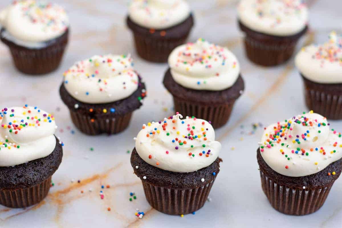 chocolate cupcakes with sprinkles in a metal baking pan. 