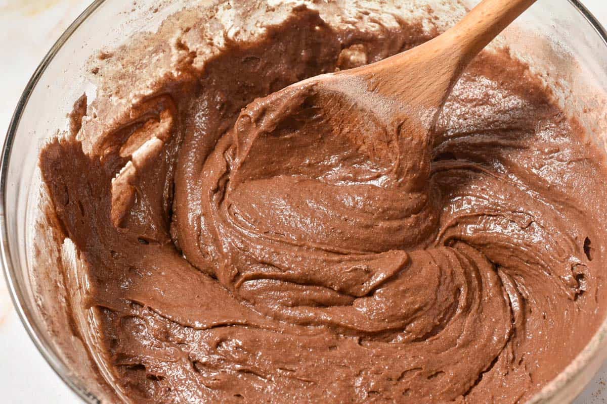 chocolate batter in mixing bowl with a spoon. 