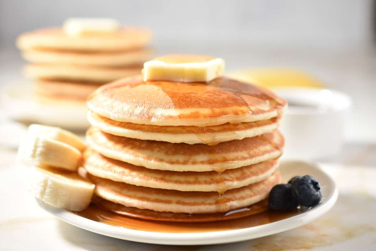 stack of pancakes with butter any syrup dripping off. 