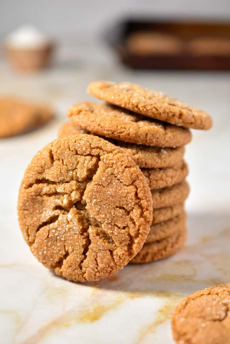 chewy molasses cookies stacked on a counter. 