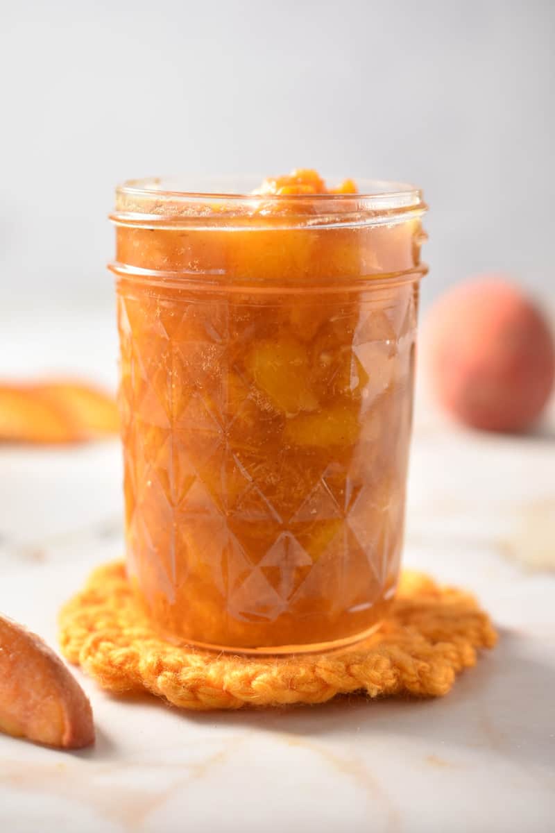 diced peaches in compote sauce in a jar. 