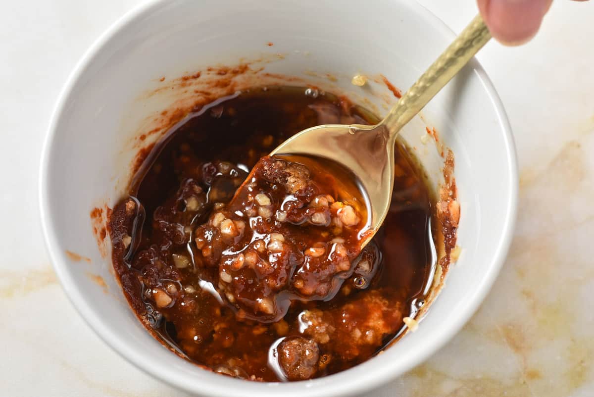 spoon mixing sauce ingredients together. 