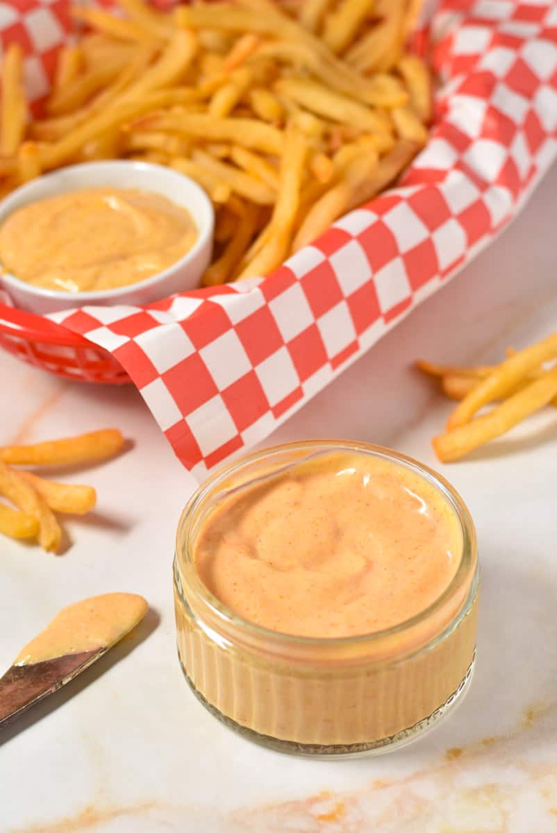 Freddy's sauce in a bowl with basket of French fries. 