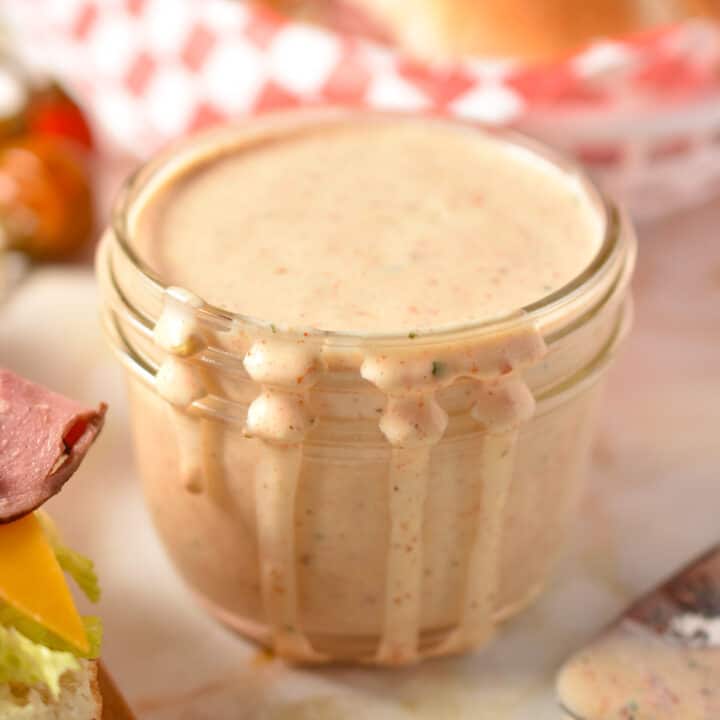 creamy ranch dressing in a cup with drips down the side.