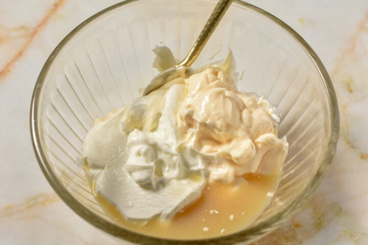 Mayo, sour cream, and lemon juice mixed together in a bowl.