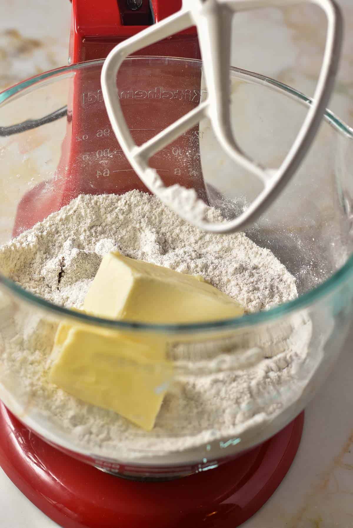 Softened butter sitting in a stand mixer with flour mixture. 