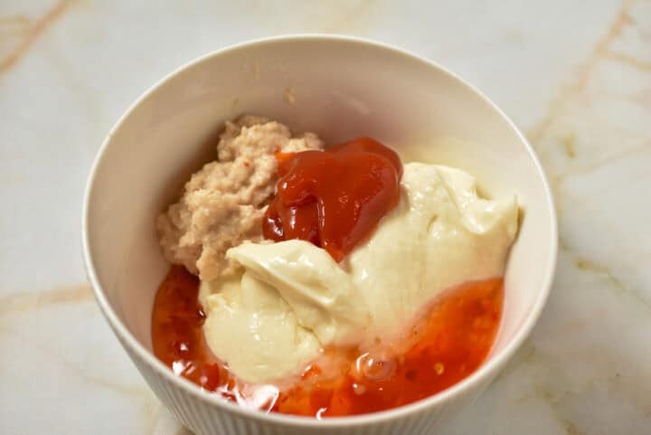 mayo, chili sauce, horseradish sauce in a bowl to be mixed.