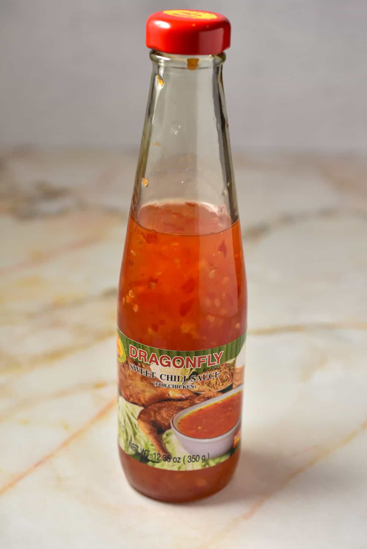 a bottle of sweet chili sauce sitting on the counter.