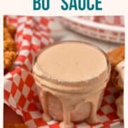 creamy sauce overflowing in a bowl, sitting on checkered paper.