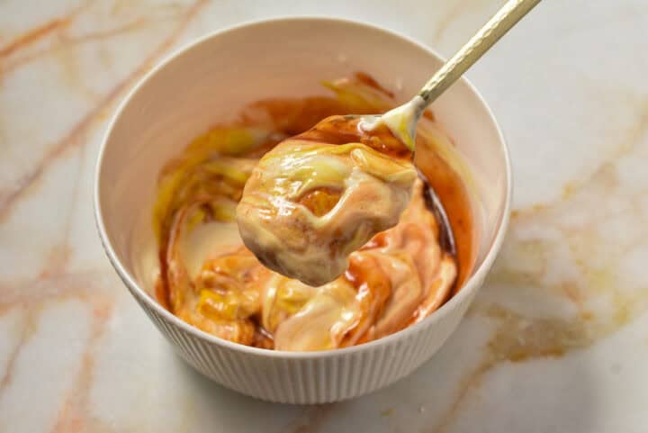 spoon mixing wet ingredients together in a bowl.