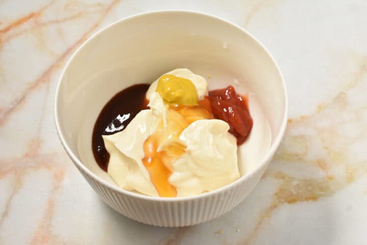 wet ingredients for sauce in a bowl, including mayo, mustard, and ketchup.