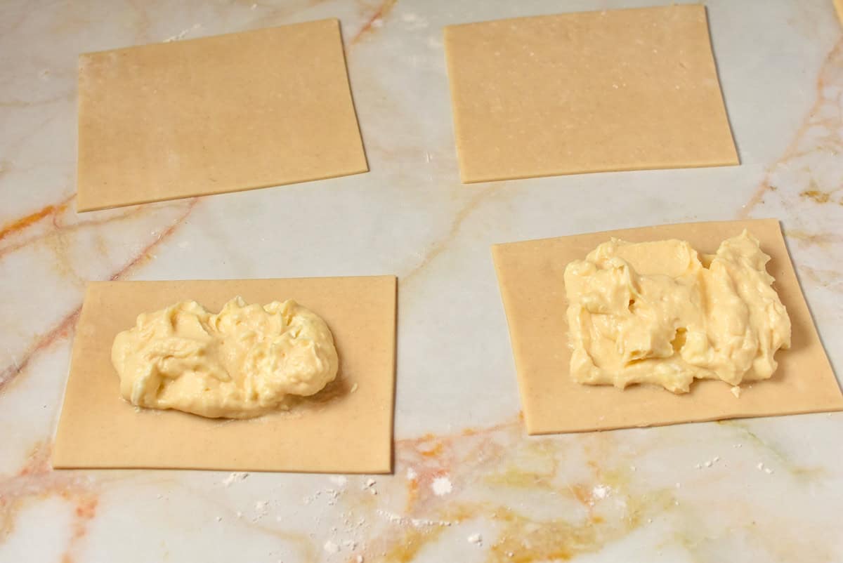 Filling spread over the individual pie crusts which are cut into rectangles.