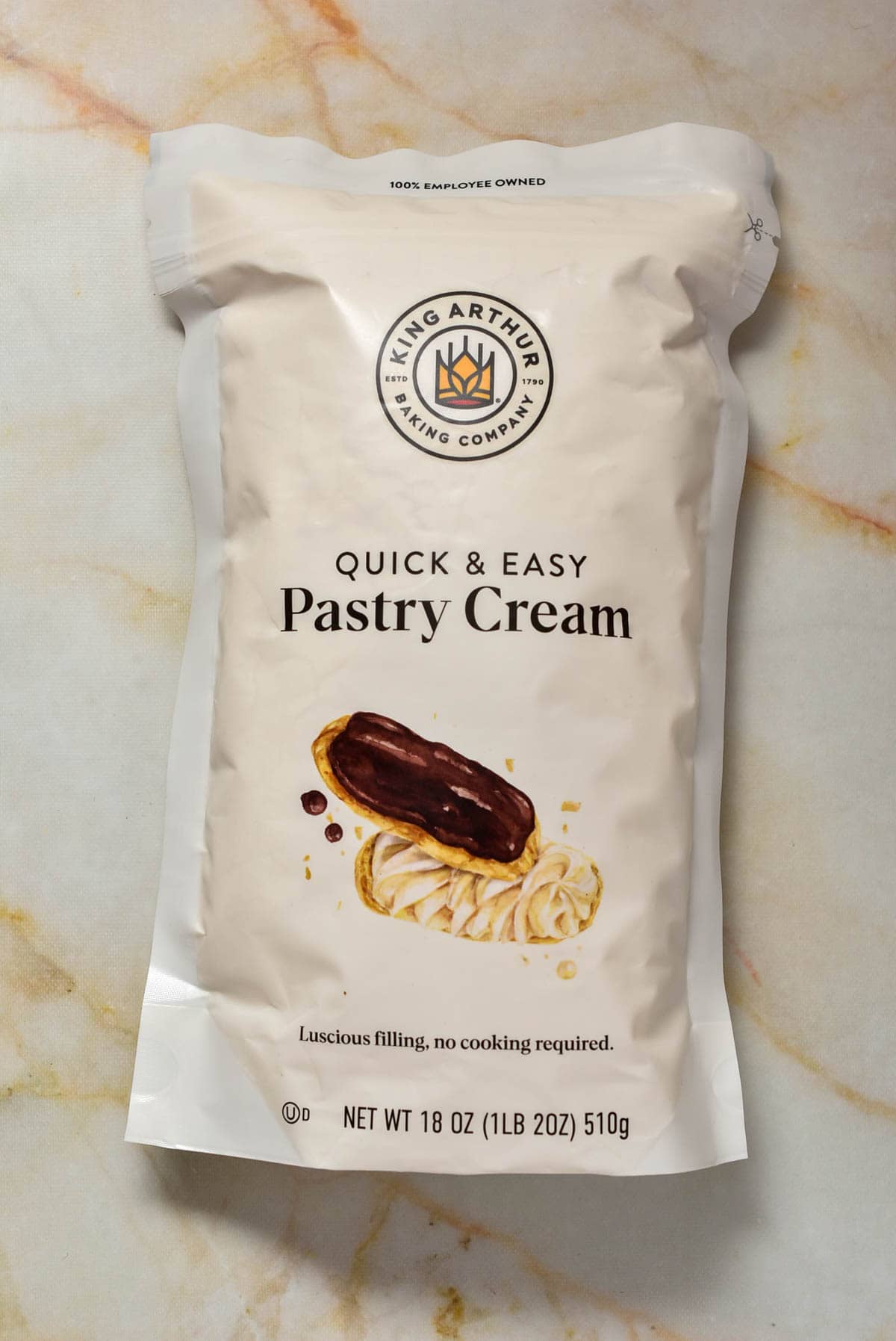 A bag of pastry cream mix laying on a marble counter.