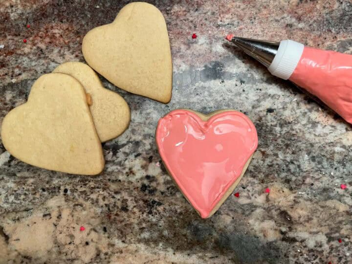 outlined heart sugar cookie filled with pink royal icing.