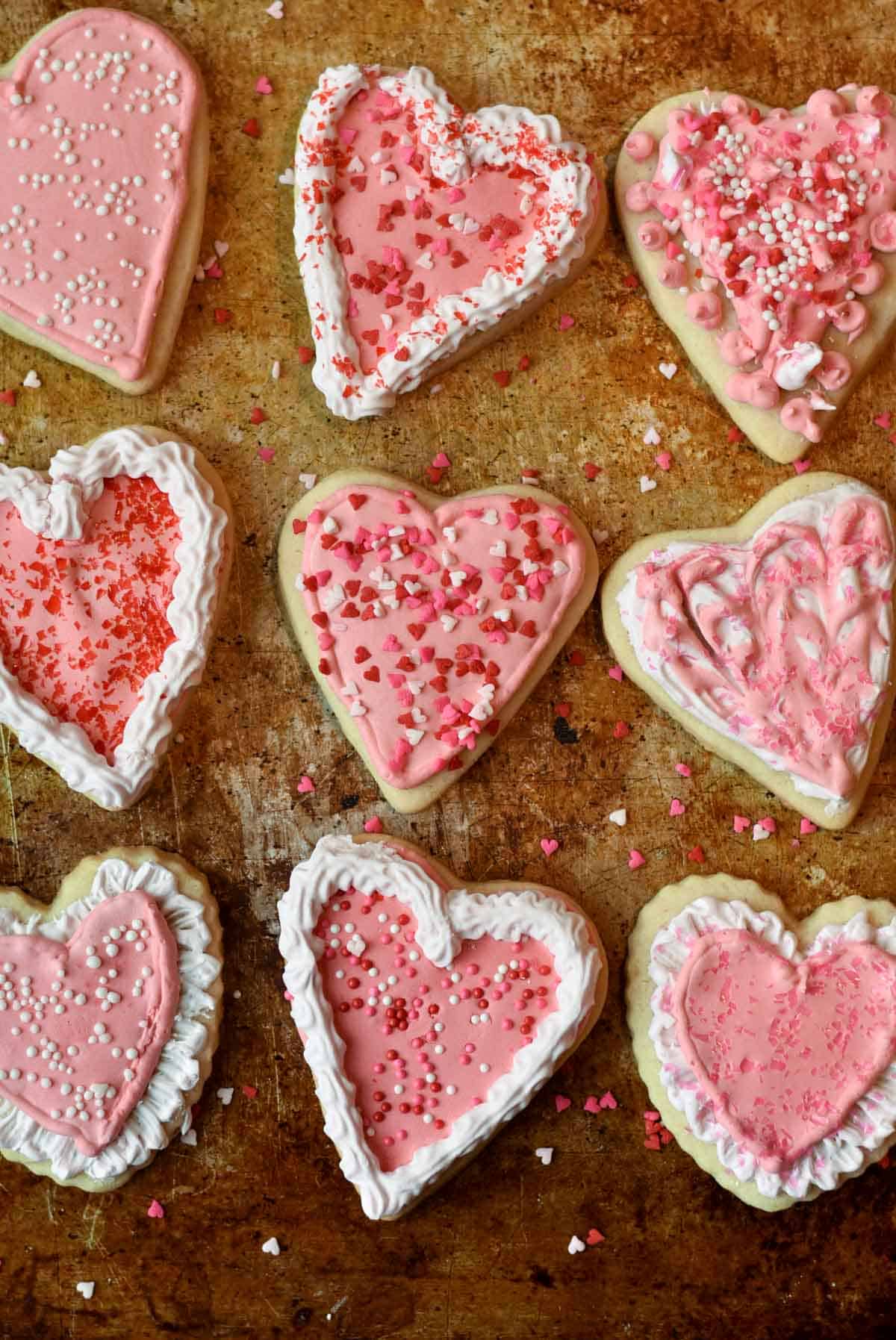 Close-up of heart-shaped sugar cookies decorated with intricate royal icing designs, showcasing their glossy finish.
