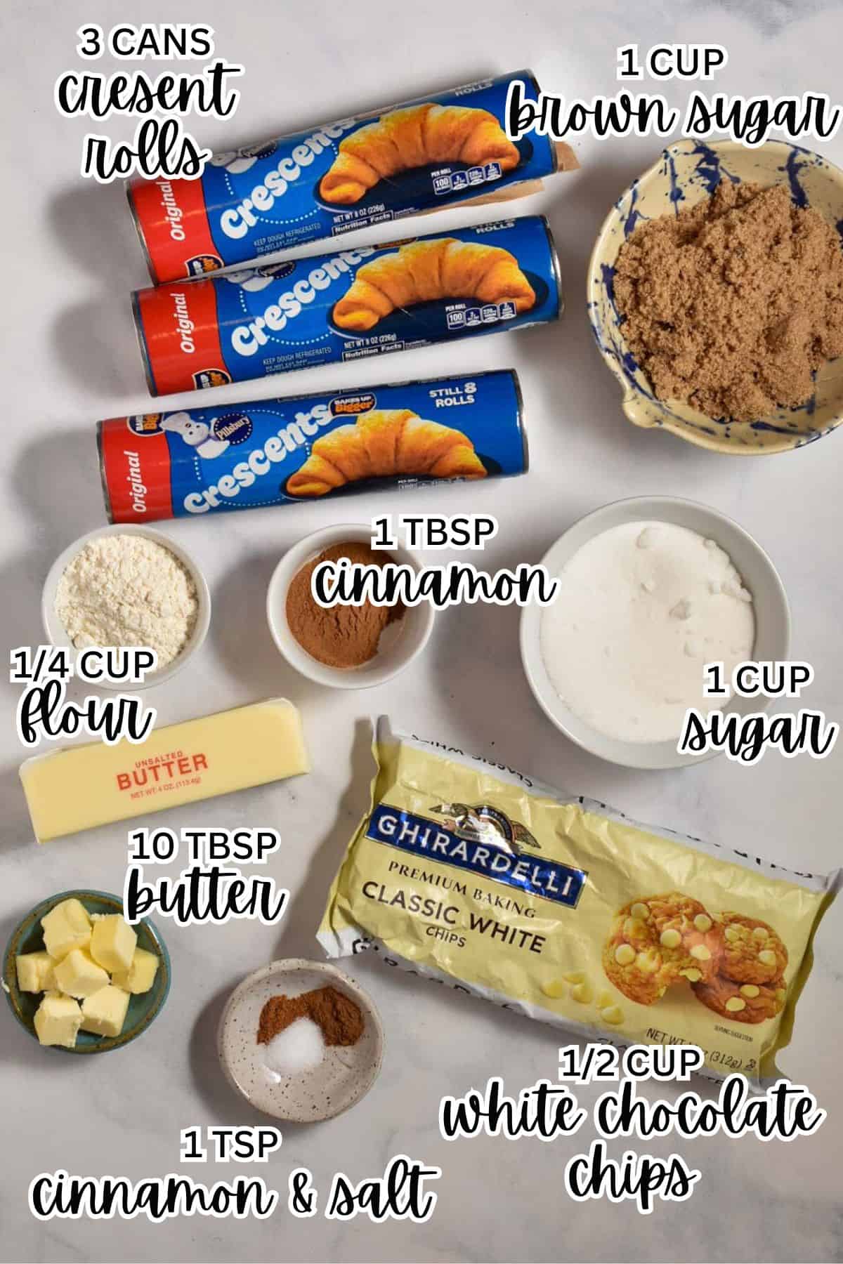 Ingredients for a Starbucks Copycat Cinnamon Pull-Apart Bread are laid out, including crescent rolls, brown sugar, flour, cinnamon, sugar, butter, white chocolate chips, and a bowl with cinnamon and salt.